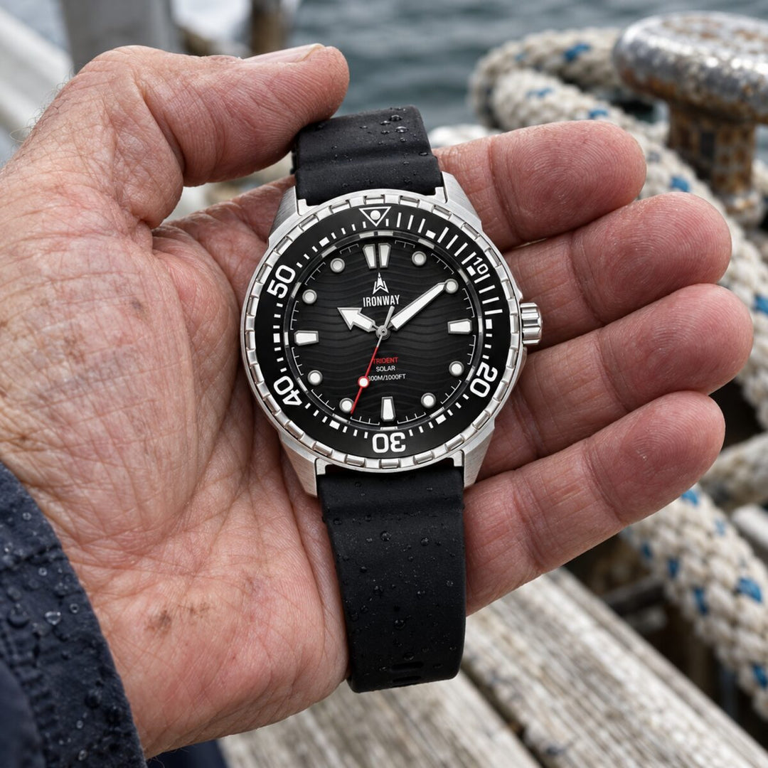 Trident 300 held in a hand, black dial, black rubber strap, 300M/1000FT on the dial